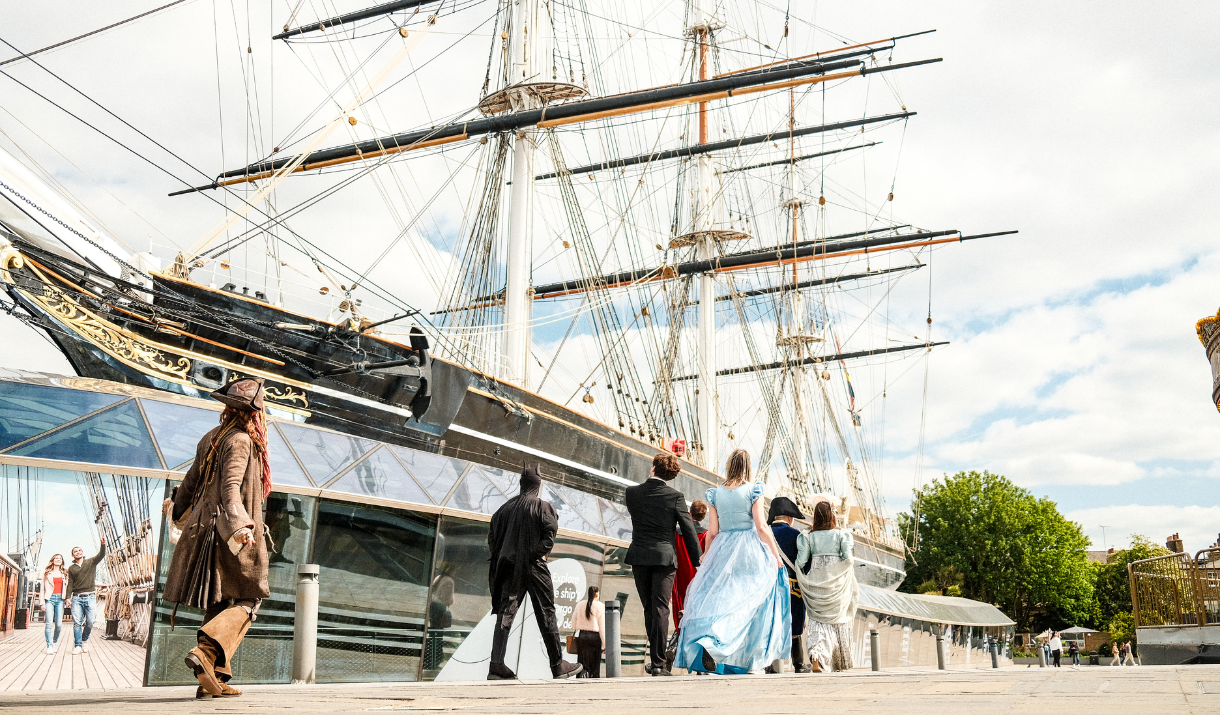 Mocie characters walk past Cutty Sark in Greenwich